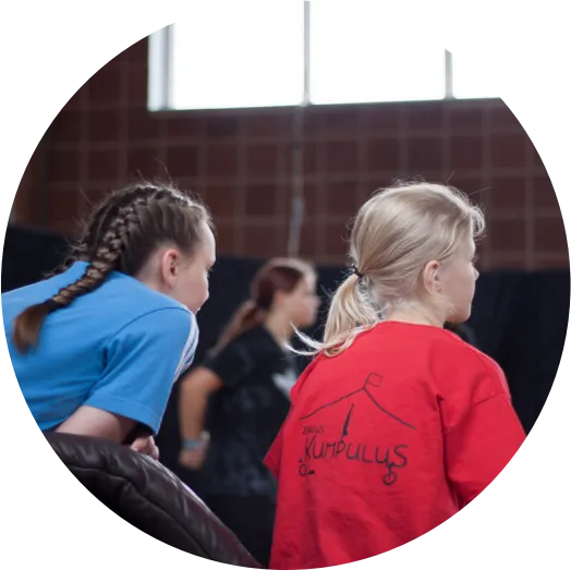 Zwei Kinder beim Training, von hinten gesehen, eines im roten Kumpulus-Shirt